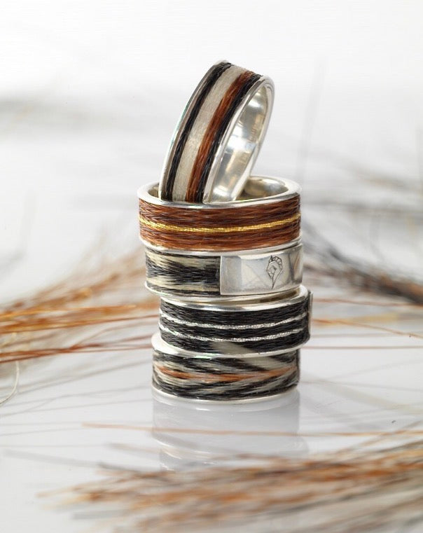 Stack of five Woven Stories Ribbon Rings in sterling silver with handwoven black, white and chestnut horse hair, including gold-thread brocade.