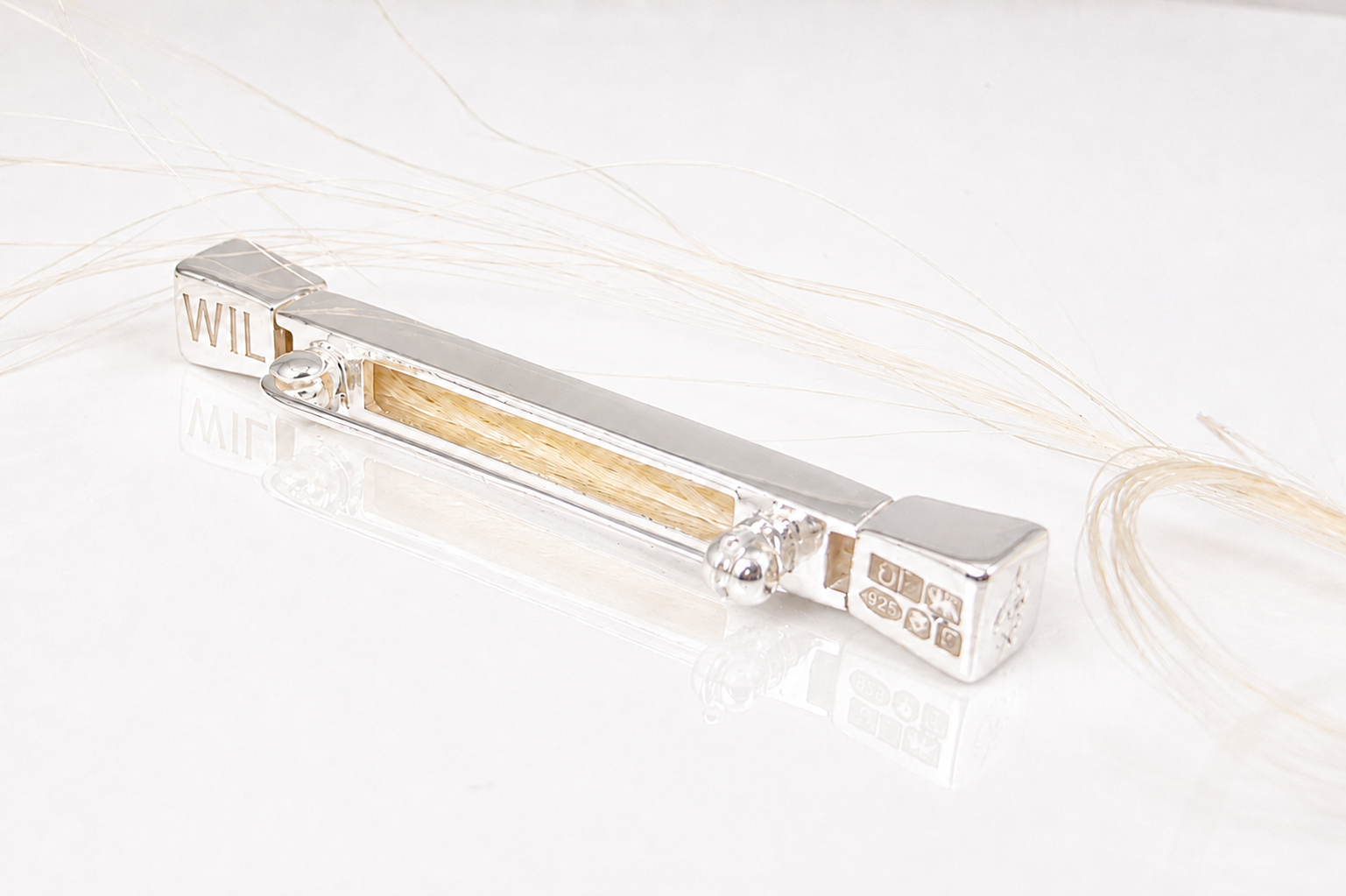 Close-up of the Forged Farriers Nail sterling silver horse hair pin, showing white or grey braid, hallmark, fastening and personalised “WILL” engraving.