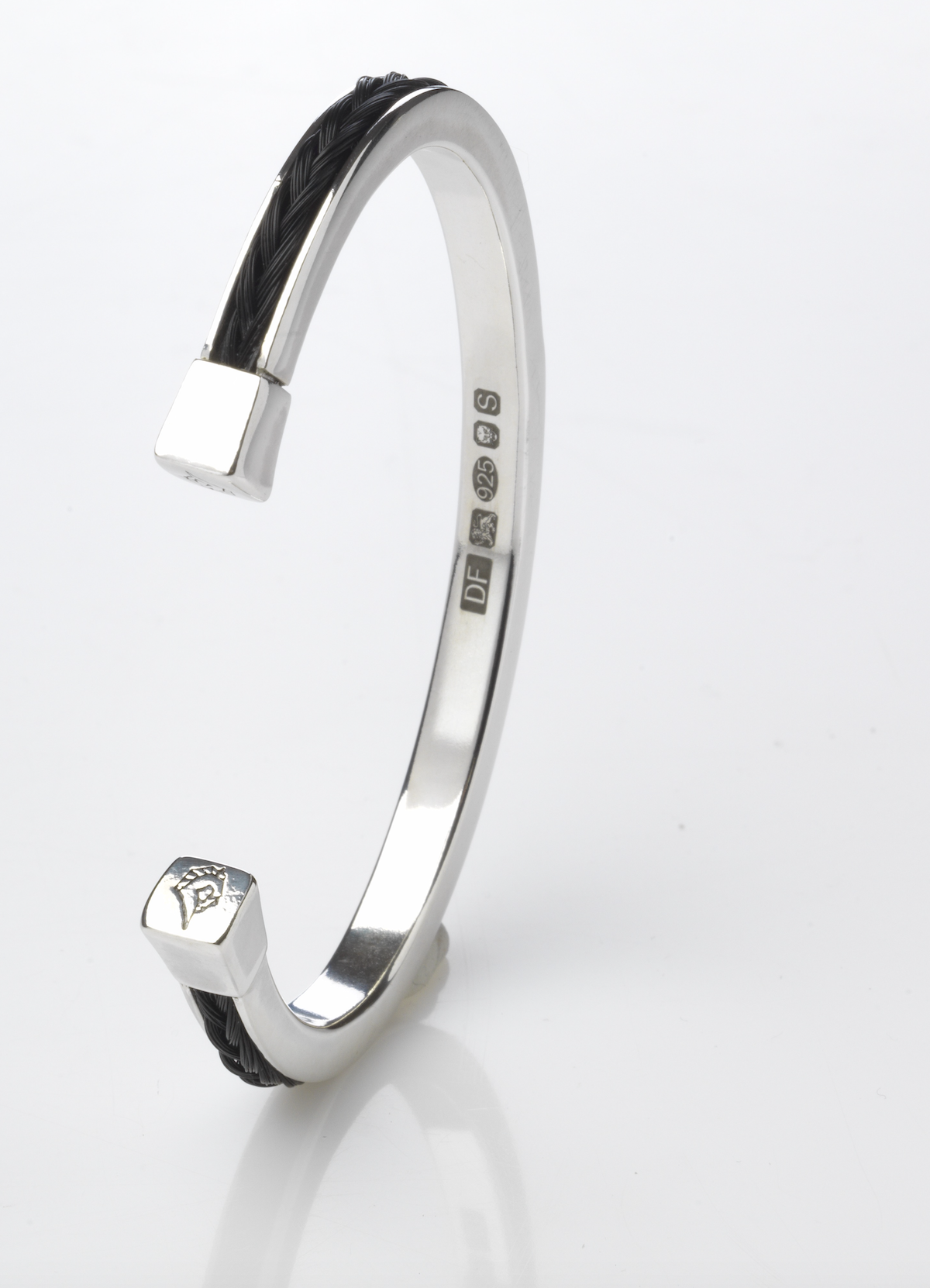 Side view of the Forged Farriers Nail sterling silver torque bangle with black braided horse hair inlay, hallmarks and engraved horse-head end cap.