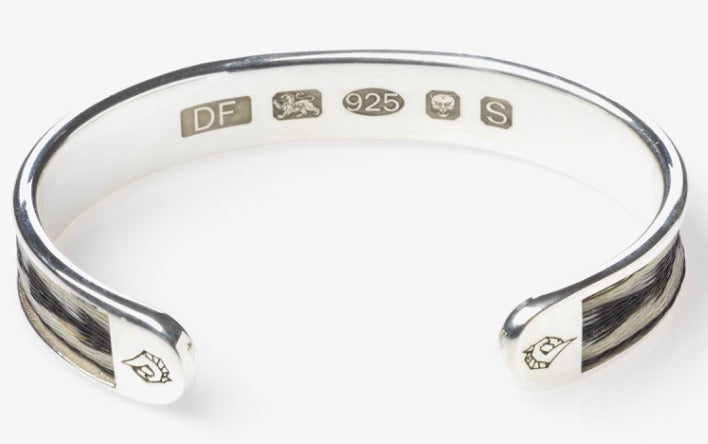 Reverse view of the Woven Stories Ribbon Torque Bangle showing the Arrows horse hair pattern, hallmarks and engraved horse-head end caps.