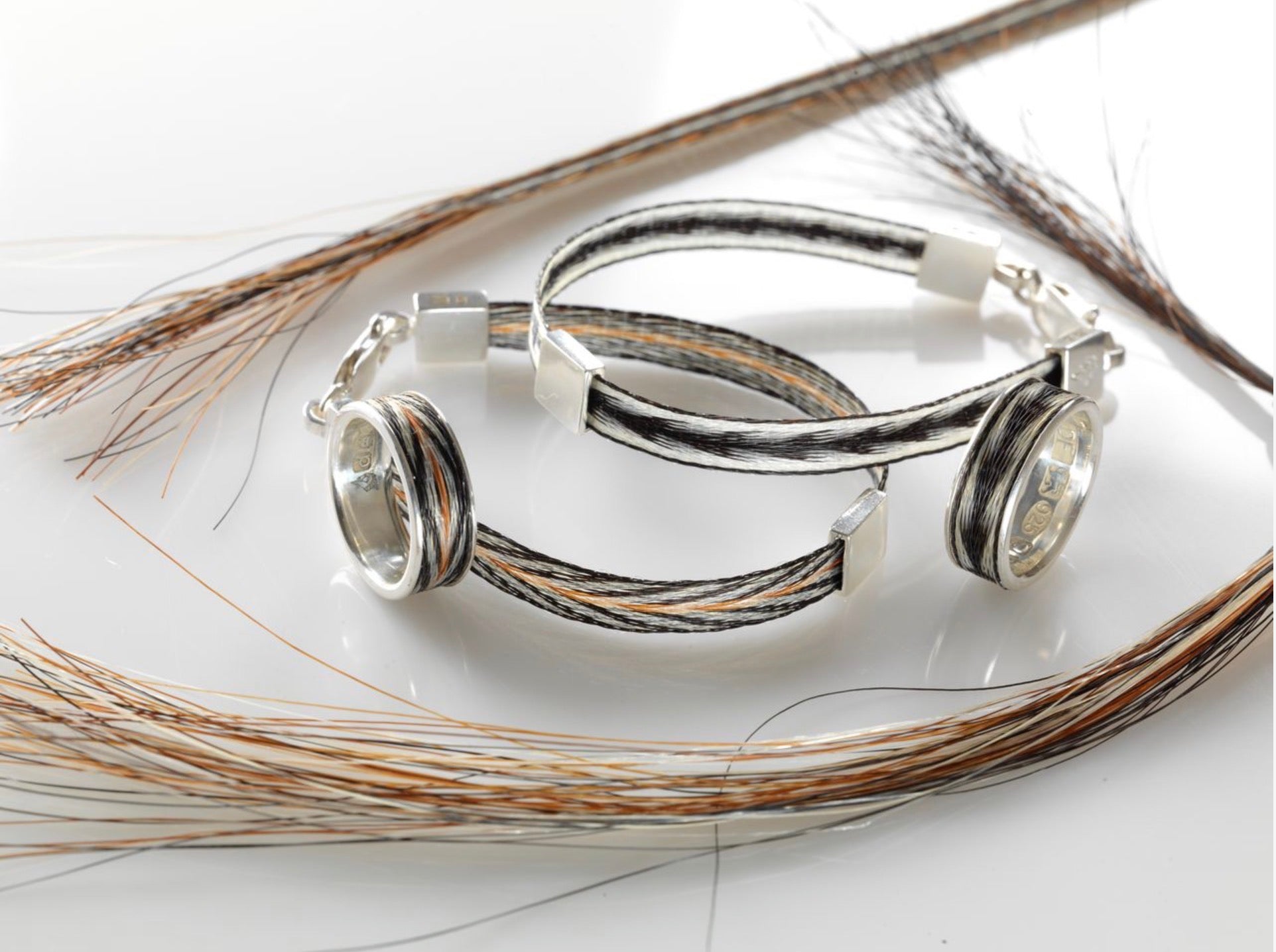 Woven Stories sterling silver ribbon rings and ribbon bracelets featuring handwoven black, white and chestnut horse hair with arrows and chevron patterns.