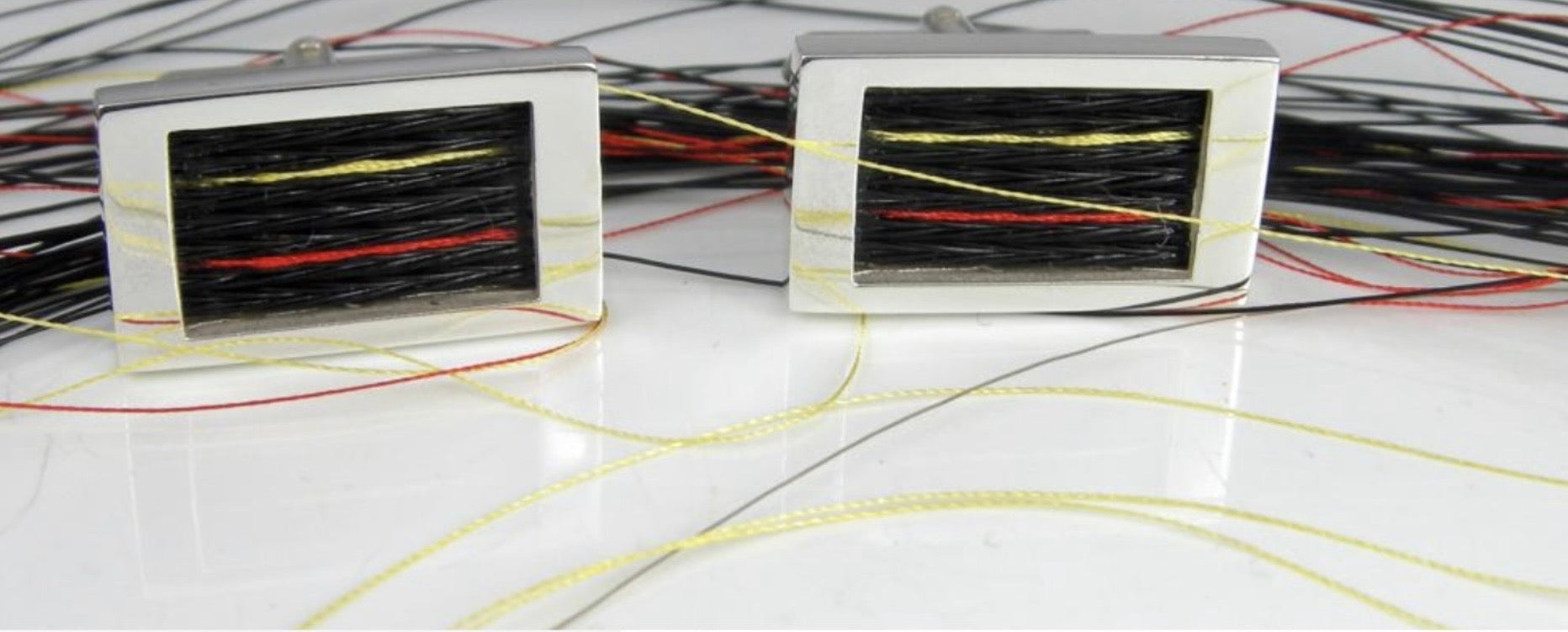 Woven Stories Ribbon Cufflinks in sterling silver with handwoven black horse hair and red and yellow Racing Silks lines.