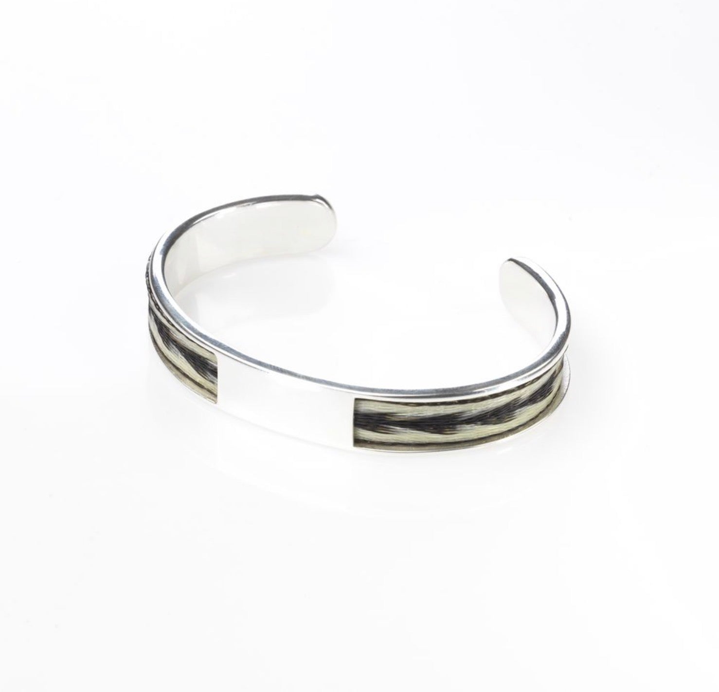 Woven Stories Ribbon Torque Bangle in sterling silver with handwoven black and white horse hair inlay, Arrows pattern.