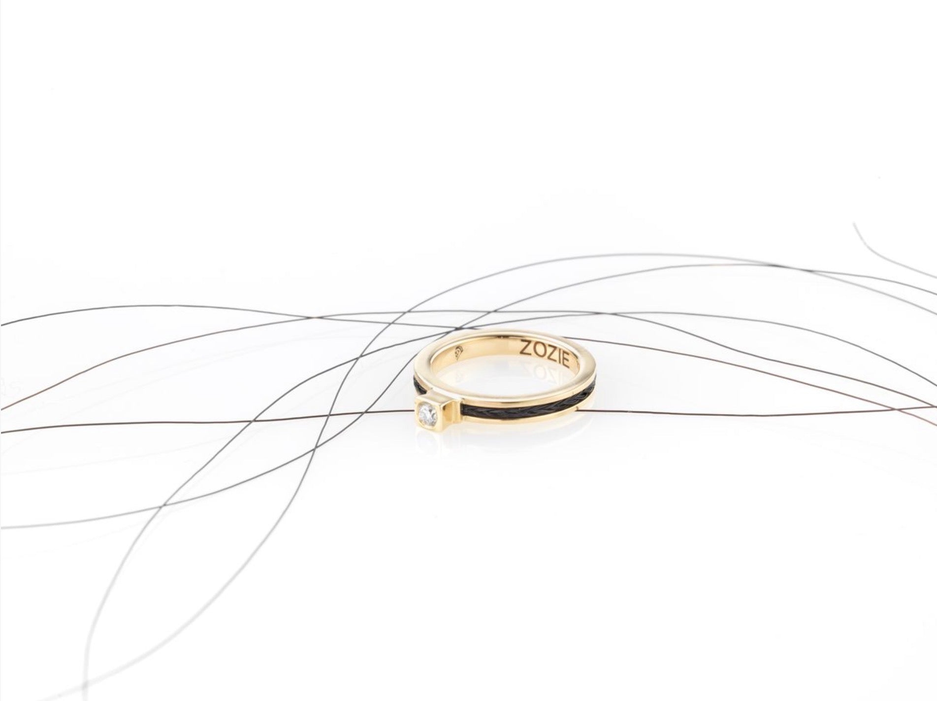 Forged horse hair birthstone ring in yellow gold with black braided horse hair, and a diamond, personalised “ZOZIE” engraving.